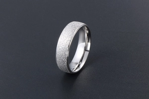 Macro shot of silver titanium steel ring with matte sand finish and polished inner band
