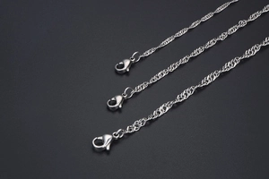 Close-up of silver-tone twisted rope chains with lobster clasps on a dark background