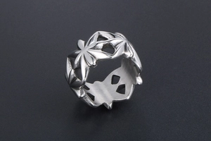 Dettaglio macro del motivo floreale traforato argento su un anello in acciaio inossidabile
