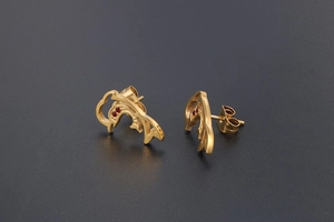 Detail of 18K gold dolphin earrings with sparkling red rhinestone eyes and sleek finish