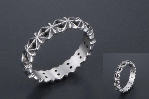 Macro detail of vintage silver starburst pattern ring with oxidized finish and inner holes