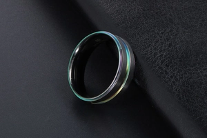Détail macro d'une bague en titane noir mat avec un bord électroplaqué arc-en-ciel