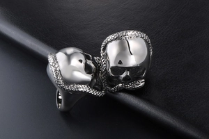 Macro detail of gothic skull and snake ring showing intricate relief scales and silver finish