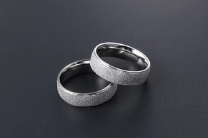 Macro view of matte brushed titanium steel couple rings with polished mirror edges
