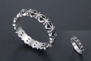 Detail of vintage silver band ring featuring engraved star patterns and aged metal finish