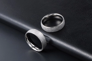 Macro view of silver titanium steel rings with textured matte finish and polished inner bands