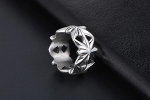 Dettaglio anello punk vintage in acciaio argento con stelle traforate e texture spazzolata