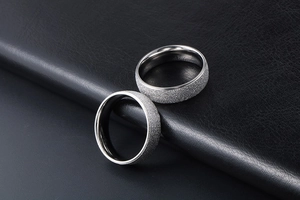 Close-up of minimalist titanium couple rings with matte starry surface and polished inner