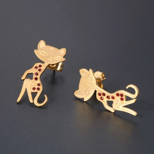 Cat-shaped rose gold stud earrings with sparkling red crystals on a dark background