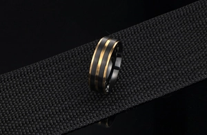 Détail de la bague en titane brossé noir avec deux lignes dorées sur sangle en nylon