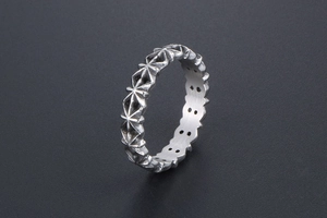 Detailed view of vintage silver ring with engraved star patterns and hollow interior