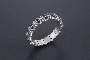 Macro view of vintage silver ring featuring engraved star patterns and oxidized finish