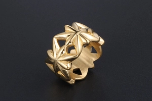 Vista macro di un anello in acciaio inossidabile dorato con intricati motivi a stella traforati