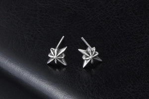 Macro shot of 3D star-shaped earrings in vintage steel with a compass star design