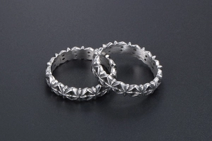 Macro detail of retro silver cross star rings with oxidized finish and gothic relief pattern