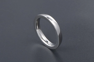 Macro detail of polished stainless steel ring showing smooth mirror finish and rounded edges
