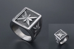 Macro shot of square signet ring with compass star relief and brushed metal finish