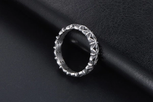 Macro shot of vintage silver ring with textured star relief and dark industrial style