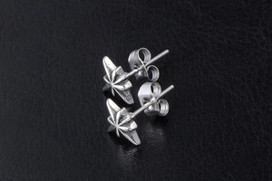 Detailed macro view of silver stainless steel octagonal star earrings on black background