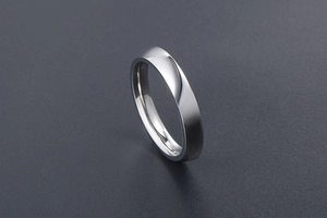 Macro view of a polished stainless steel ring showing its smooth curved surface and thickness