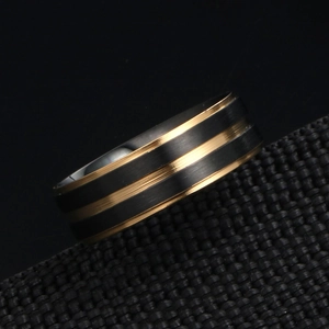 Bague homme en acier titane noir brossé avec détails dorés vue sous un angle latéral