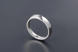 Macro shot of minimalist polished silver titanium steel ring on textured background