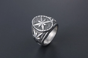 Détail d'une bague argentée vintage avec relief étoile boussole et motifs feuilles