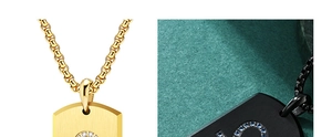 Detail of gold and black dog tag necklaces with rhinestone accents and brushed metal finish