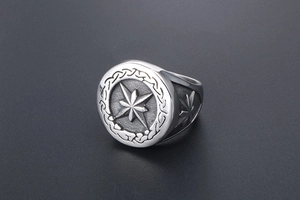 Macro shot of silver vintage signet ring featuring engraved star and textured edge