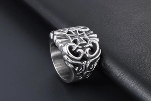 Detail of vintage stainless steel ring featuring maltese cross and hollow scrollwork