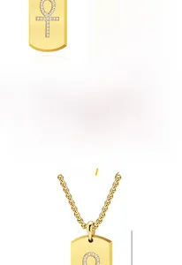 Detailed close-up of Ankh cross pendant in gold and black finish with sparkling stones