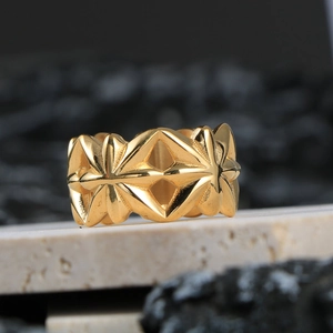 Anello da uomo in acciaio al titanio con motivo geometrico traforato e finitura dorata