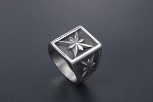 Close-up of matte stainless steel signet ring with vintage black etched star pattern