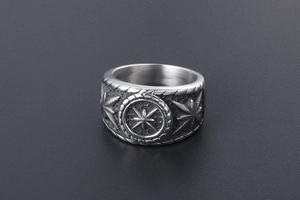 Close-up of vintage steel ring featuring embossed octagonal star and palm leaf carvings