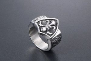 Détail macro d'une bague pour homme en acier avec blason fleur de lys en relief argenté