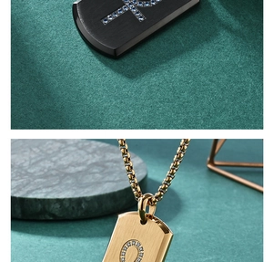 Detailed macro of Ankh cross and horseshoe pendants in black and gold stainless steel