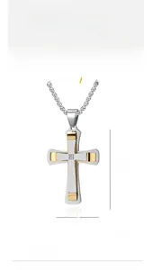 Détail macro d'un pendentif croix en acier titane bicolore avec pierre sertie et 53 mm