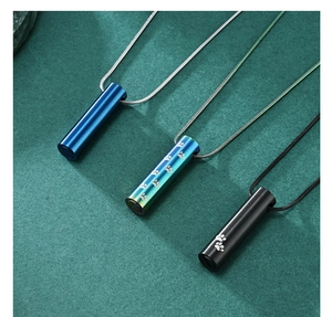 Three cylindrical pet cremation urn necklaces in blue, rainbow, and black stainless steel