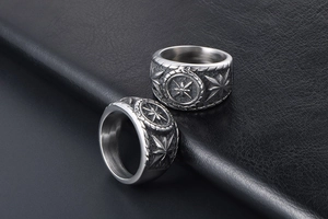 Macro shot of silver punk signet rings with octagonal star relief on black leather