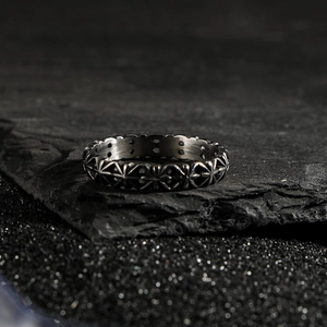 Vintage industrial style metal ring with engraved star flower patterns on black stone