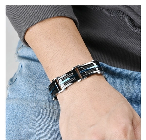 Gros plan du bracelet pour homme en fils d'acier superposés noir et bleu sur le poignet