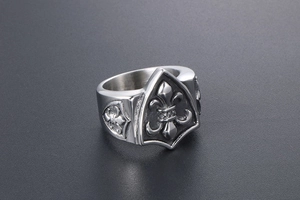 Détail macro d'une bague chevalière en acier titane avec motif de blason Fleur-de-lis