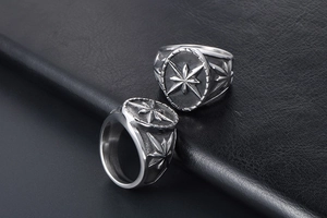 Gros plan sur une bague vintage en acier avec motif étoile gravé sur cuir noir