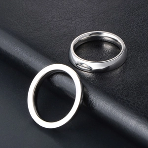 Minimalist titanium steel couple rings with a polished silver mirror finish on leather