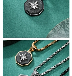 Detail of octagonal carbon fiber pendant necklace with silver star in gold and black finishes