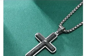 Detail of cross pendant with carbon fiber inlay and star motif on box chain