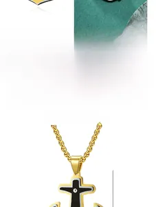 Détail d'un pendentif ancre en acier titane doré avec une croix noire incrustée