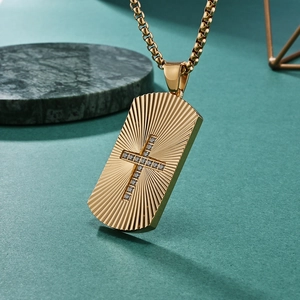 Gold rectangular dog tag necklace with radiating sunburst texture and centered cross stone