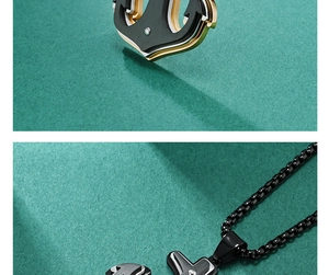Gros plan d'un pendentif ancre bicolore avec design mécanique et chaîne noire élégante