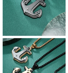 Détail du collier pendentif ancre bicolore avec texture en métal brossé sur marbre